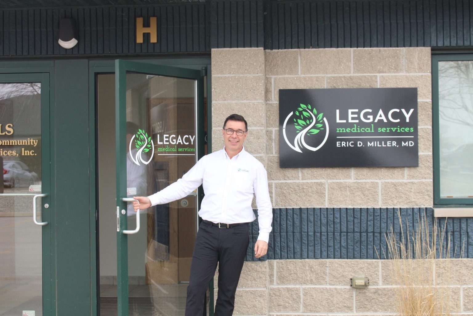 Dr. Eric Miller welcoming patients at the Legacy Medical Services entrance